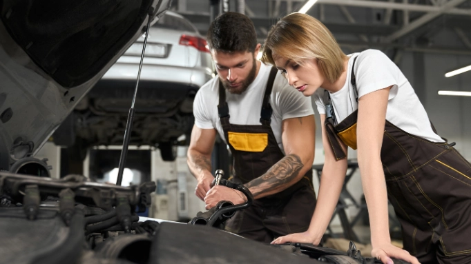 Two people repairing a car