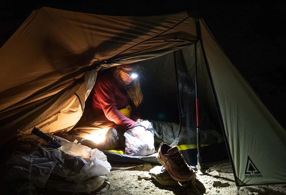 Photo of someone using the best headlamp for camping.