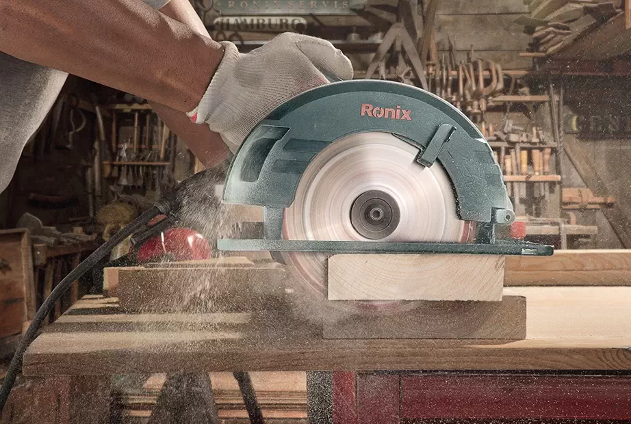 A man using a circular saw to cut through wood