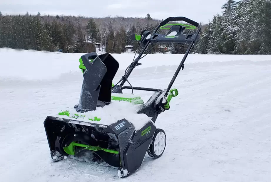 A Green works snow blower is used to clear a driveway